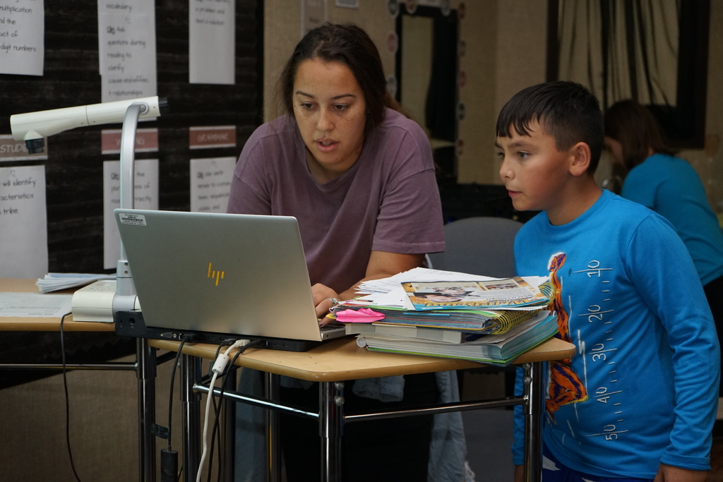 Student and teacher working on a computer